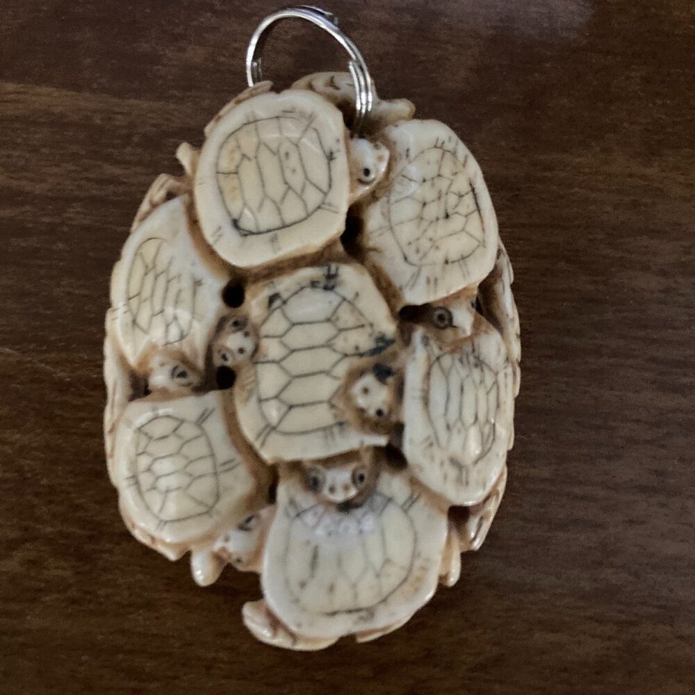 Hand-Carved Bone Pendant – Circle of Seven Turtles